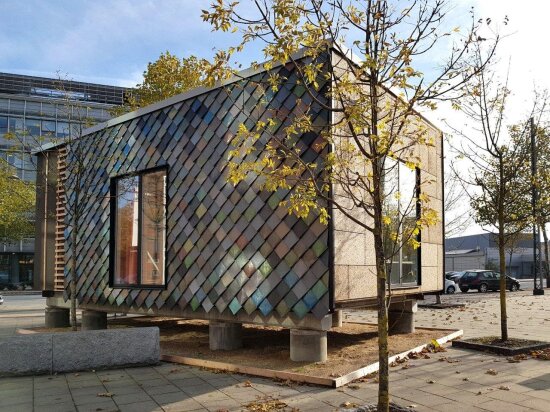 Et minihus på betongklosser på et bygulv.