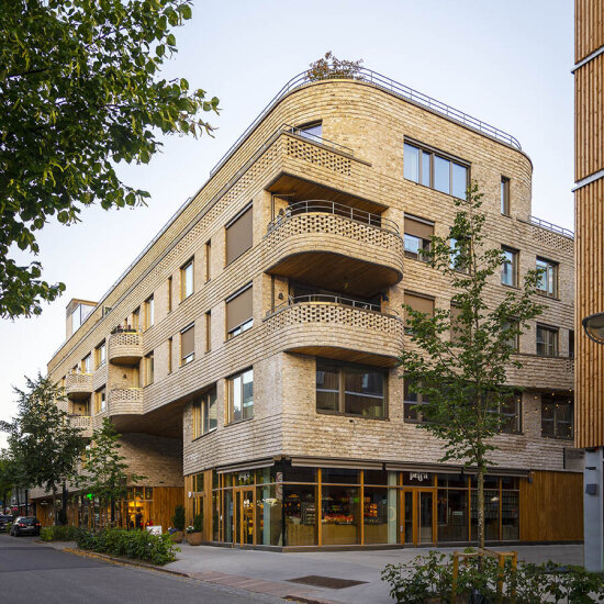 En femetasjes bygning med teglsteinsfasade og avrundede former på balkongene.
