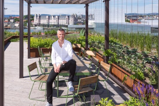 DOGAs administrerende direktør Tor Inge Hjemdal sitter på Vestremøbler på en takterrasse med utsikt mot Oslo havnelager.