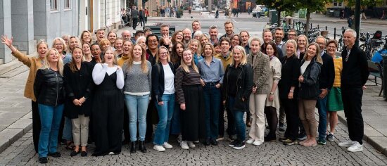 Gruppebilde av mange smilende mennesker