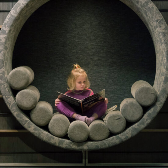 Jente leser bok på Fubiak, Deichman Furuset.