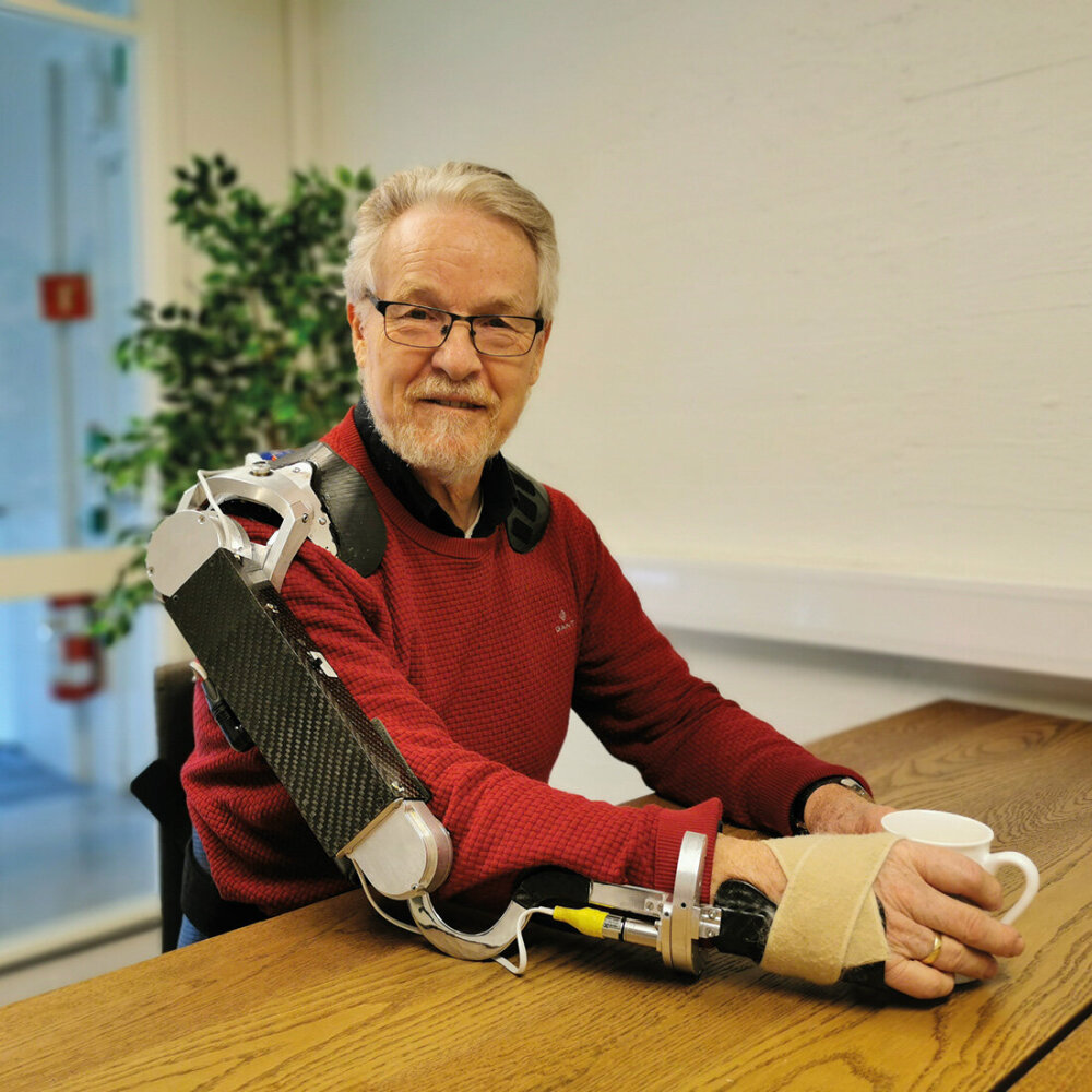 Mann med armprotese holder en kaffekopp.