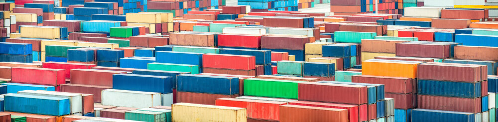 Containere i ulike farger stablet opp i Hamburg havn. 