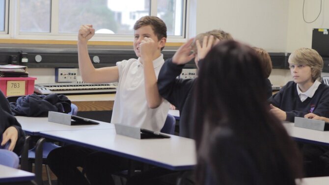 boy cheering in a classroom.