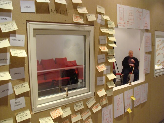 Window with post it notes and older user in background