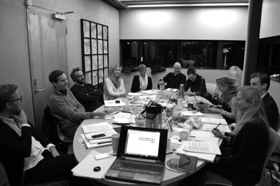Jurymedlemmer for Innovasjonsprisen for universell utforming 2014 sitter rundt et bord og diskuterer søknader.