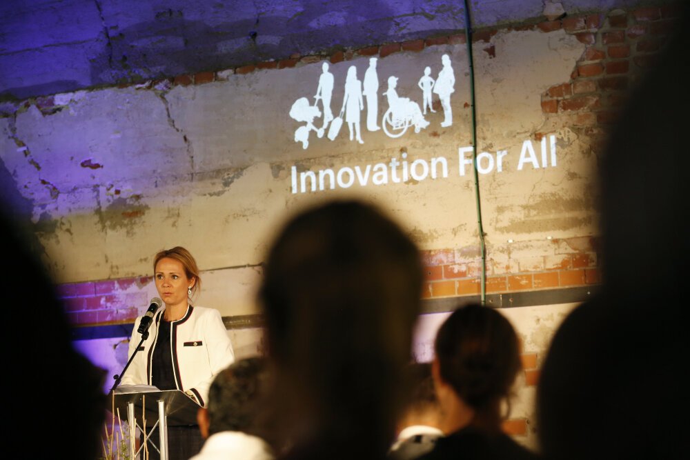Dame på scene som holder foredrag. 

Bilde fra den sjette 'Innovation for all – European Business Workshops in Inclusive Design' på DOGA, Hausmanns gate 16 i Oslo, 7.-8. juni 2018. 