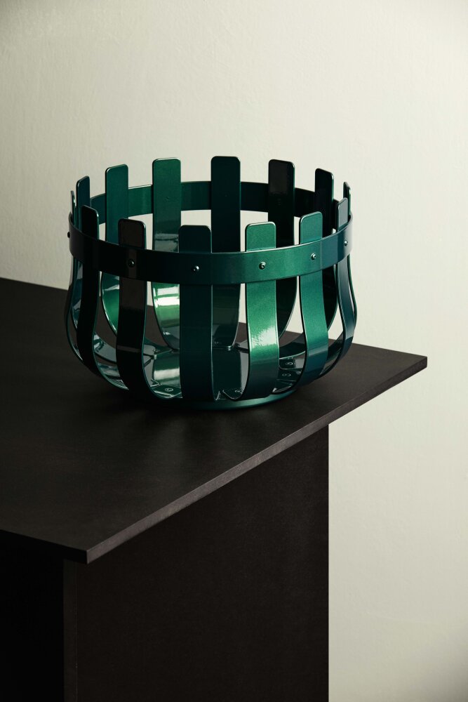 En kurv som ligner på tradisjonelle kurver laget av trespiler, men denne er laget av aluminium og farget grønn. Kurven heter Strand og er designet av Vera & Kyte. Skal stilles ut på den norske fellesutstillingen under Milano Design Week.
