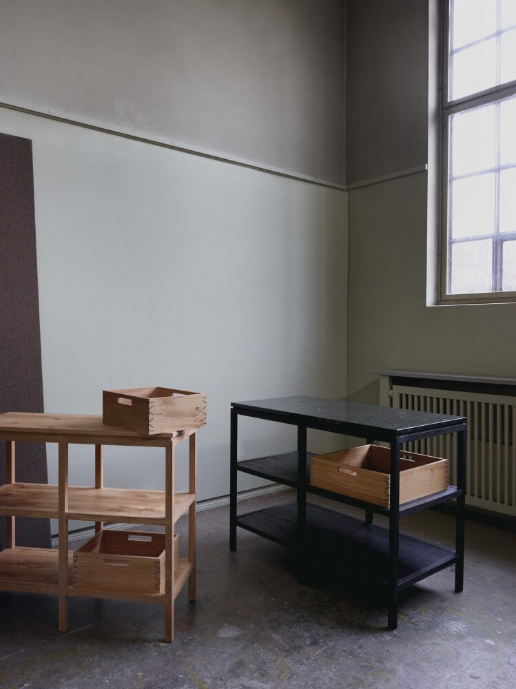 To kjøkkenmoduler i tre, en lys og en mørk.