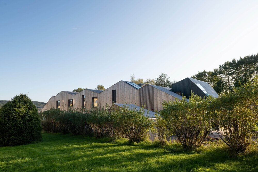 Siluetten av et trehus mot blå himmel. Foto