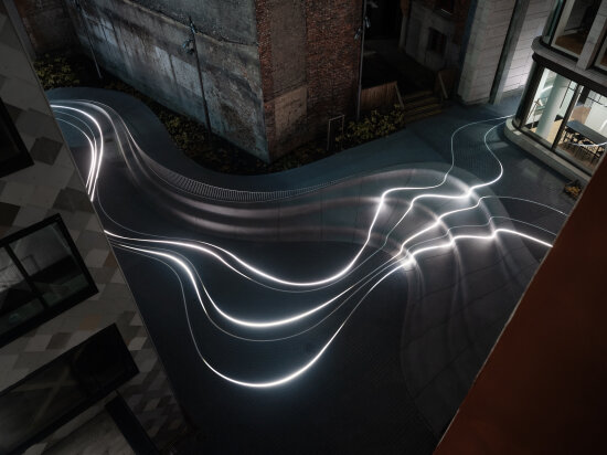 Amfi mellom bygårder med lys i bakken. Foto