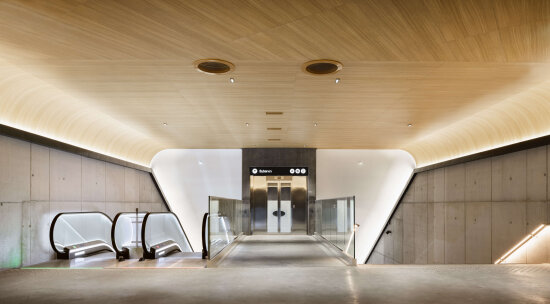 Åpent og lyst inngangsparti med rulletrapp, heis og trappeløp. Foto