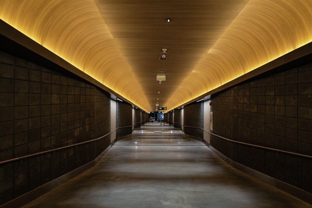 Stor hall med svak helning i gulvet. Treverk i taket. Foto