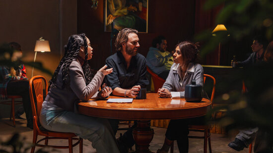 Tre voksne mennesker sitter rundt et bord med lydopptakeren Nomono på bordet. Foto