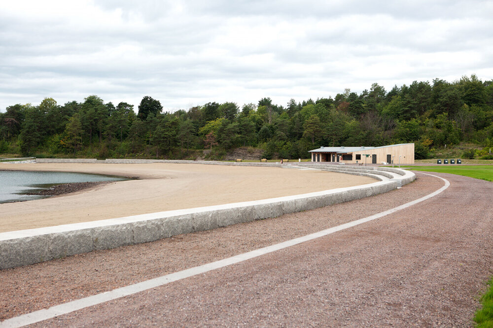 Strandlinje med sitteatrium i stein rundt. Foto