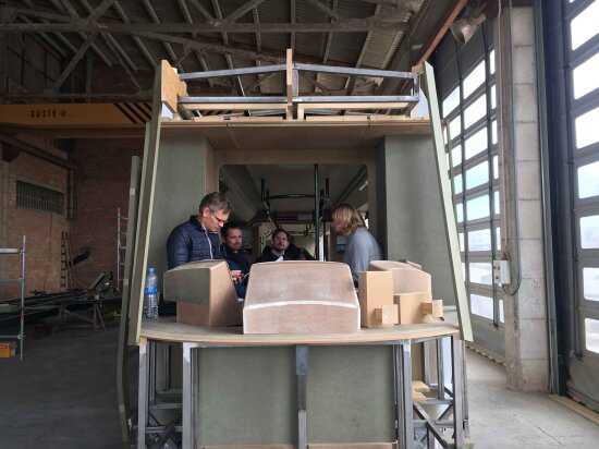 Fullscala modell av trikkens førerhus med fire mennesker inni. Foto