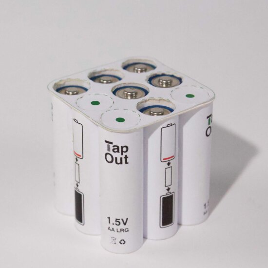 En hvit beholder for batterier. På toppen et display som viser en oversikt over brukte og ubrukte batterier.