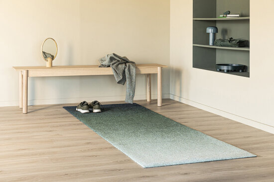 Interiør av lys gang med blåtonet teppe på gulvet. Foto