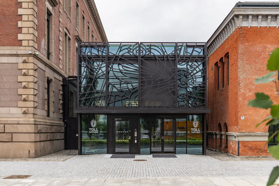 Fasaden på de restaurerte tollbodene i Oslo. To teglsteinsbygninger er føyd sammen av en sort fasade av smijern og glass.