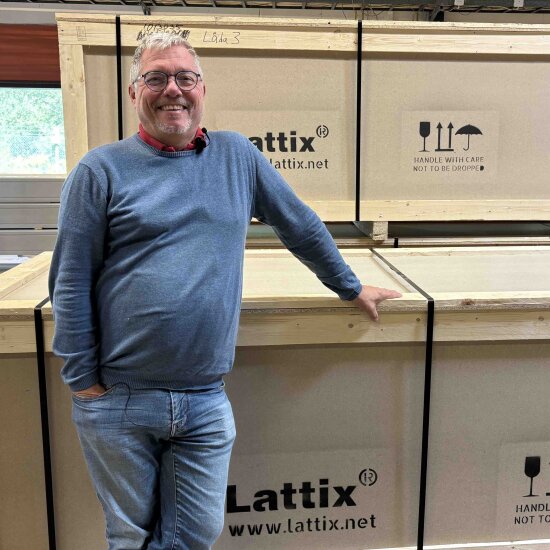 En blid mann foran to store trekasser