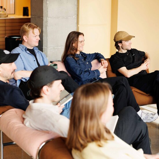 Seks ungdommer sitter i en sofa og ser samme vei