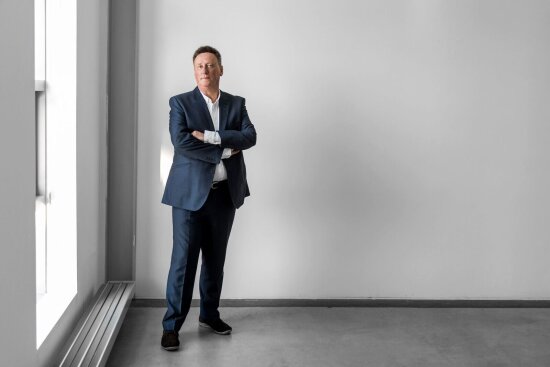 Dale Harrow infront of a wall posing.