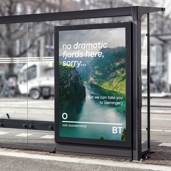 Gateskilt-reklame på busstopp for Oslo bussterminal, med teksten «no dramatic fjords here, sorry ... but we can take you to Geiranger» på bilde av Geirangerfjorden.