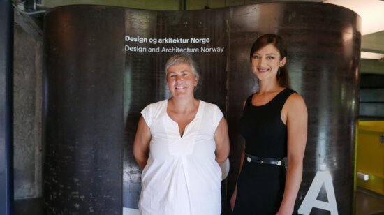 Fra venstre: Beate Hølmebakk, manthey kula og og Charlotte Hansson, LCLA. De to kvinnene står foran en bølgeformet metallvegg med påskriften Design og arkitektur Norge, Design and Architecture Norway