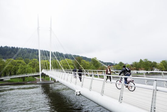 Ypsilonbroen i Drammen. Hvis fotgjengerbro med barn og syklister en sommerdag.